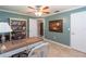 Comfortable home office with a ceiling fan, travertine tile floors, built in book shelves and a desk and chair at 11210 Wheeling Dr, Tampa, FL 33625