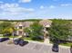 Aerial view of condos with well-kept landscaping, assigned parking, and mature trees providing ample shade at 1231 Godavari Way # 103, Wesley Chapel, FL 33543