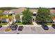 Aerial view shows condo complex with mature trees, assigned parking spaces, and appealing landscaping at 1231 Godavari Way # 103, Wesley Chapel, FL 33543