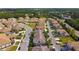 Aerial view showcasing a well-planned community with tennis courts and beautiful tree-lined streets at 1231 Godavari Way # 103, Wesley Chapel, FL 33543