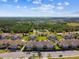 Aerial view of community featuring manicured lawns, serene pond, and well-maintained condo buildings at 1231 Godavari Way # 103, Wesley Chapel, FL 33543