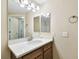 Bathroom with quartz counters, wood cabinets, and framed vanity mirror at 1231 Godavari Way # 103, Wesley Chapel, FL 33543