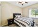 Bedroom with wood-look floors, ceiling fan, and large window at 1231 Godavari Way # 103, Wesley Chapel, FL 33543