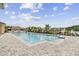 Sparkling community pool overlooking a serene lake, surrounded by paved deck and lush landscaping at 1231 Godavari Way # 103, Wesley Chapel, FL 33543
