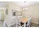Bright dining room features a chandelier, stylish mirror, and seating for six at 1231 Godavari Way # 103, Wesley Chapel, FL 33543