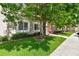 Exterior view of condo building with a tree, green lawn, and sidewalk at 1231 Godavari Way # 103, Wesley Chapel, FL 33543