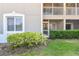 Condo exterior view featuring window, screened door to a balcony and nicely maintained landscaping at 1231 Godavari Way # 103, Wesley Chapel, FL 33543