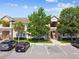 Condo exterior showing multiple units, parking spaces, landscaping, and architectural stone details at 1231 Godavari Way # 103, Wesley Chapel, FL 33543