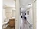 Hallway with grey wood-look tile, leading to bathroom and living area at 1231 Godavari Way # 103, Wesley Chapel, FL 33543
