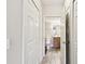 Hallway view of a clean bathroom with wood-look floors and white fixtures and a walk-in shower at 1231 Godavari Way # 103, Wesley Chapel, FL 33543