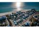 Stunning aerial view of a coastal community with houses, a pristine beach, and beautiful turquoise waters at 12409 Gulf Blvd, Treasure Island, FL 33706