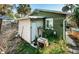 Secluded backyard with storage area, hot tub, lush greenery, and quirky details for privacy and charm at 12409 Gulf Blvd, Treasure Island, FL 33706