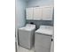 Bright laundry room featuring a white washer and dryer set, complemented by above-appliance white cabinets at 12447 Drysdale St, Spring Hill, FL 34609