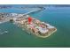 An aerial view of condo community on the water with a boat dock, swimming pool and bay bridge at 126 1St E St # 102, Tierra Verde, FL 33715