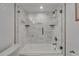 Bright bathroom with modern bathtub, textured tile surround, and glass shower enclosure at 126 1St E St # 102, Tierra Verde, FL 33715