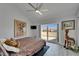 Bright bedroom with a large sliding door to a balcony, ceiling fan, and contemporary flooring at 126 1St E St # 102, Tierra Verde, FL 33715