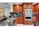 Gourmet kitchen featuring sleek black granite countertops, stainless steel appliances, and custom wood cabinetry at 126 1St E St # 102, Tierra Verde, FL 33715