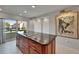 Kitchen island boasting granite countertops and modern cooktop, illuminated by natural light from a sliding glass door at 126 1St E St # 102, Tierra Verde, FL 33715