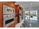Kitchen features granite countertops, stainless steel appliances, custom wood cabinets, and natural light from a window at 126 1St E St # 102, Tierra Verde, FL 33715