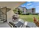 Covered patio with seating, grill, lush lawn, and beautiful building views at 126 1St E St # 102, Tierra Verde, FL 33715