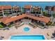 A top-down view of a jacuzzi and swimming pool with resort style seating on brick pavers surrounded by lush plants at 126 1St E St # 102, Tierra Verde, FL 33715