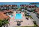 Aerial view of a community pool, with brick pavers, umbrellas, lounge chairs and lush tropical landscaping at 126 1St E St # 102, Tierra Verde, FL 33715