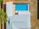 Aerial view of a screened in pool with a covered patio with a light colored roof at 14136 Payne St, Spring Hill, FL 34609