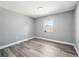 Clean bedroom featuring stylish flooring, neutral gray walls, and a window that provides great light at 14136 Payne St, Spring Hill, FL 34609