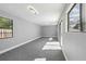 Large bonus room featuring gray carpet, natural light, and sliding glass door access to the backyard at 14136 Payne St, Spring Hill, FL 34609