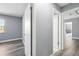 Hallway featuring grey walls and wood floors with an open doorway to another room at 14136 Payne St, Spring Hill, FL 34609
