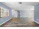 Bright, open living room with modern gray walls, sleek wood-look floors, and abundant natural light from a large window at 14136 Payne St, Spring Hill, FL 34609