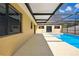 Poolside view of patio with screen enclosure and sliding glass doors to the home's interior at 14136 Payne St, Spring Hill, FL 34609
