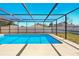 Screen enclosed pool with bright blue water, surrounded by a concrete patio at 14136 Payne St, Spring Hill, FL 34609