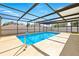 Enclosed pool with a full screen surround, bright blue water, and ladder at 14136 Payne St, Spring Hill, FL 34609