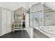 The bathroom offers bright natural lighting with dual closets and a glass encased tub with decorative wall tiling at 1500 Elmwood St, Clearwater, FL 33755