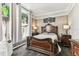 Bedroom with an ornate wooden bed frame, side tables, and decoratively paneled wall, showing a cozy room at 1500 Elmwood St, Clearwater, FL 33755