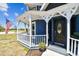 Close-up view of the black front door and charming covered porch on a blue Victorian home at 1500 Elmwood St, Clearwater, FL 33755