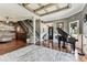 Open-concept living space with hardwood floors, piano, staircase, and plenty of natural light at 1500 Elmwood St, Clearwater, FL 33755