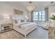 Serene main bedroom with a decorative chandelier, accent wall, and neutral color palette at 17130 Moonflower Dr, Venice, FL 34293