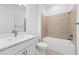 Bright bathroom featuring a tub with tile surround and a white vanity with a contemporary faucet at 17200 Luminous Ave, Venice, FL 34293