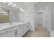 Bright bathroom featuring a double vanity with white cabinets and tiled flooring at 17200 Luminous Ave, Venice, FL 34293