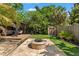 Beautiful backyard showcasing a stone fire pit, wooden deck, and a storage shed amidst tropical foliage at 1816 E 15Th Ave, Tampa, FL 33605