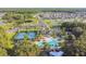 Aerial shot of the community pool, tennis courts, clubhouse and adjacent neighborhood with a wooded area at 19316 Eagle Creek Ln, Tampa, FL 33647