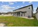 Back exterior view shows covered patio with ceiling fan, lawn, fenced in yard, and AC units at 19316 Eagle Creek Ln, Tampa, FL 33647