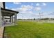 Spacious backyard with healthy green grass, white fence, and covered patio, perfect for outdoor enjoyment and relaxation at 19316 Eagle Creek Ln, Tampa, FL 33647