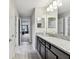 Modern bathroom with granite countertops, double mirrors, and neutral paint at 19316 Eagle Creek Ln, Tampa, FL 33647