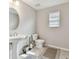 Half bath with a modern pedestal sink, white toilet, neutral walls, and tile flooring at 19316 Eagle Creek Ln, Tampa, FL 33647