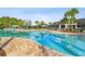A beautiful community pool with palm trees, clubhouse and lounge chairs for relaxing and enjoying the outdoors at 19316 Eagle Creek Ln, Tampa, FL 33647