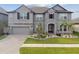 Elegant two-story home featuring stone accents, a well-manicured lawn, and a welcoming entrance at 19316 Eagle Creek Ln, Tampa, FL 33647