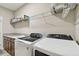 Bright laundry room with granite counters, a sink, and modern, front-loading washer and dryer at 19316 Eagle Creek Ln, Tampa, FL 33647